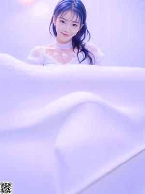 A woman in a white lingerie posing for a picture.