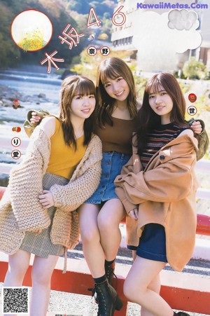 A group of young women standing next to each other on a bridge.