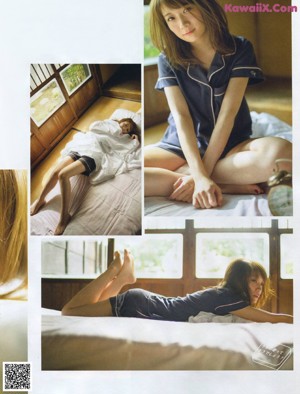 A woman laying on top of a bed next to a book.