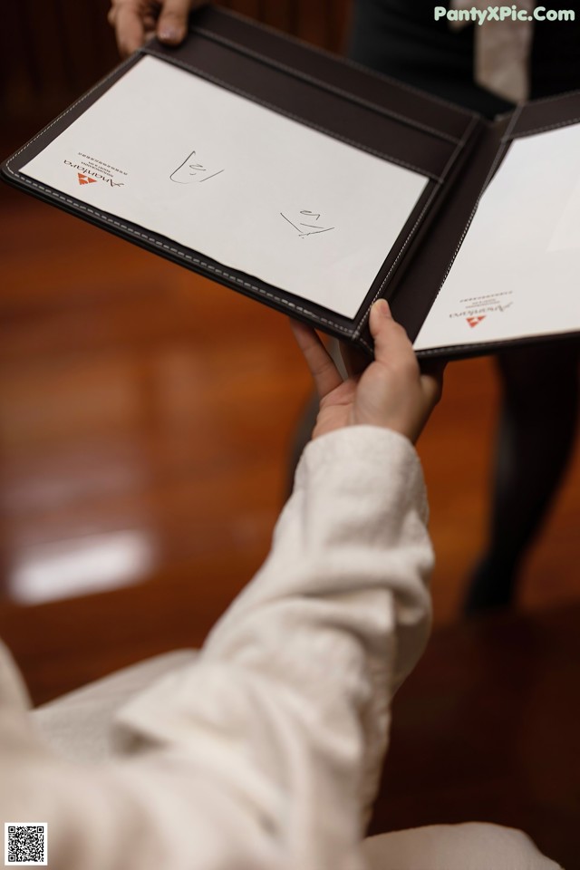 A person holding a folder with a drawing on it.