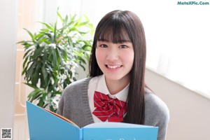 A young woman in a school uniform posing for a picture.