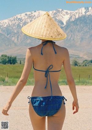 A silhouette of a woman standing in front of a blue sky.