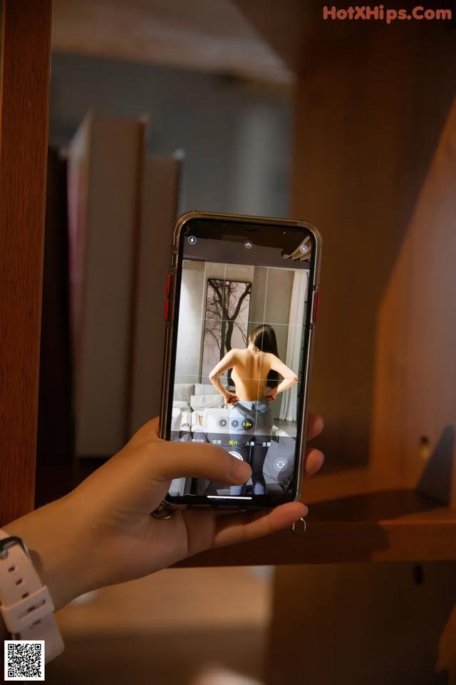 A person taking a picture of a woman in a mirror.