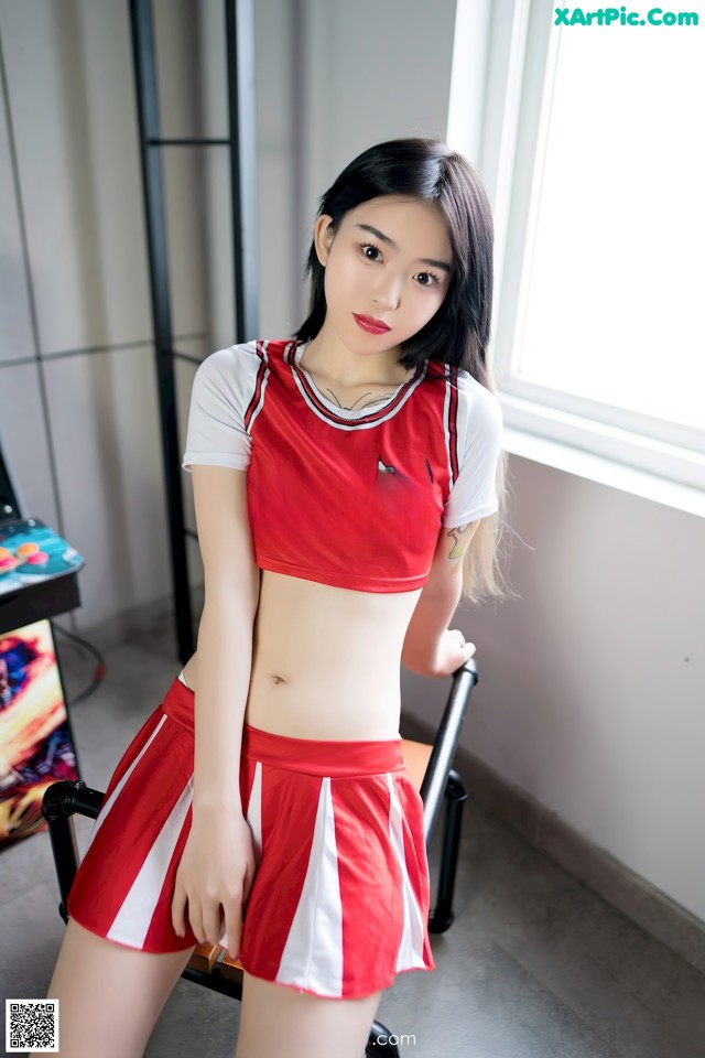 A woman in a red and white basketball uniform posing for a picture.