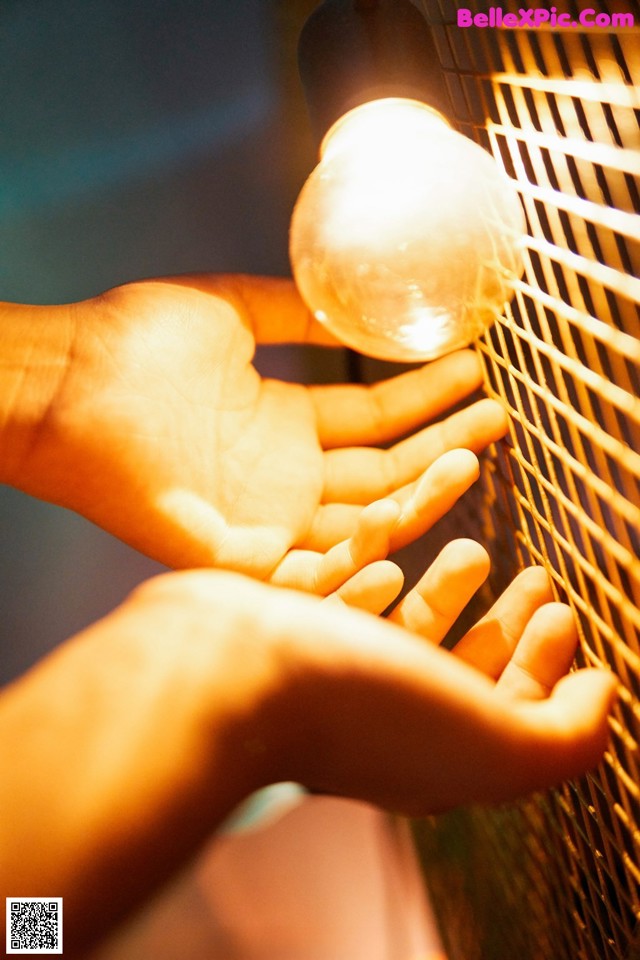 A person holding a light bulb in their hand.