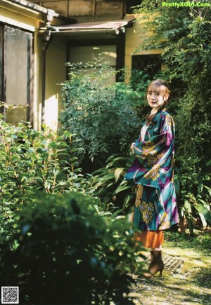 a woman wearing a purple sweater and white shorts