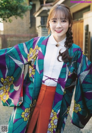 A woman in a colorful kimono standing in a garden.