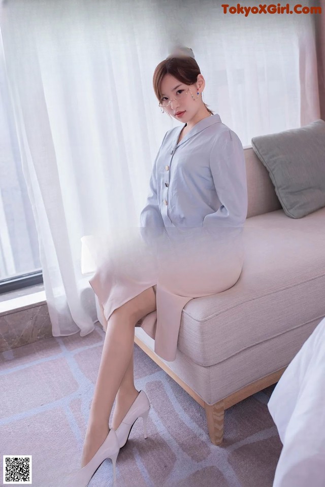 a woman sitting on top of a couch next to a window