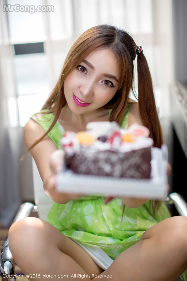 A woman sitting in a chair holding a piece of cake.