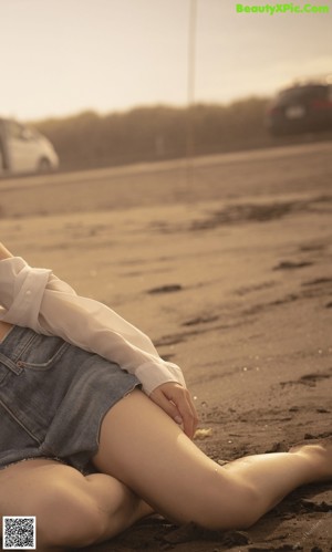 A woman in a bikini sitting on the beach.