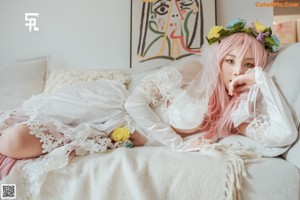 A woman in a white lingerie sitting on the floor.