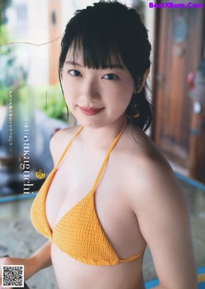 A woman in a yellow bikini posing for a picture.