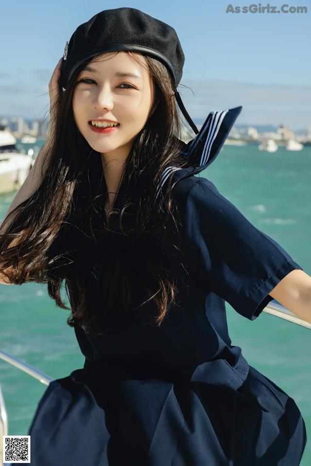 A woman in a sailor outfit posing on a boat.