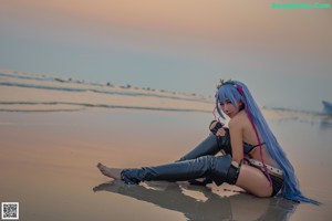A woman with long purple hair is posing for a picture.