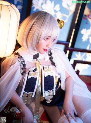 A woman sitting on a window sill next to a lamp.