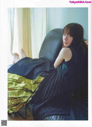 A magazine spread with a woman laying on the ground.