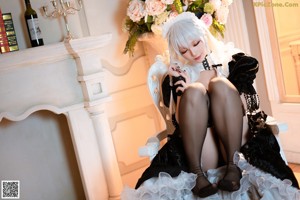A woman in a black and white dress sitting on the floor.